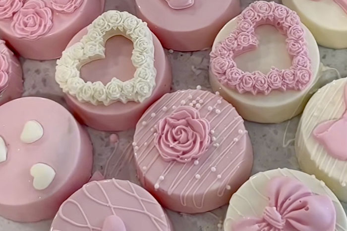 Pink cake pops with various toppings, including colorful sprinkle
